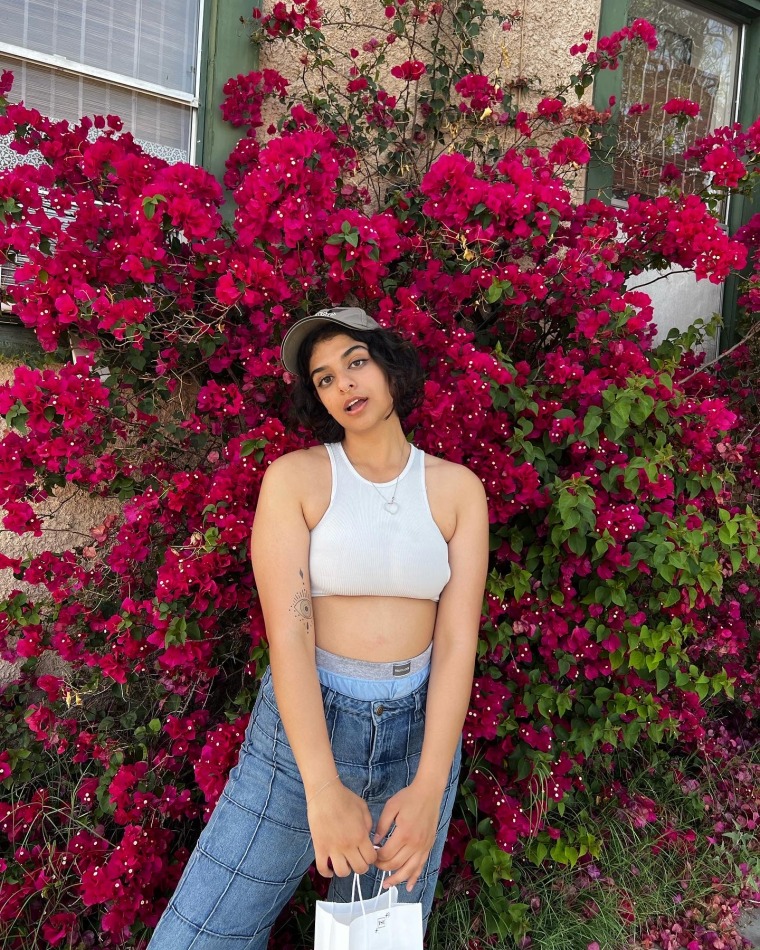 Nousha standing in front of a hot pink bougainvillea