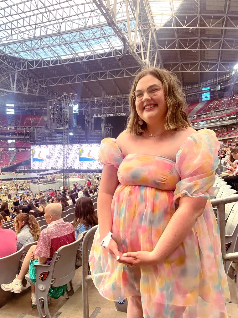 A photo of Lilly at the Eras tour with a poofy, rainbow dress