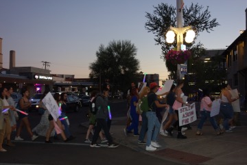 folks marching in street with signs and banner